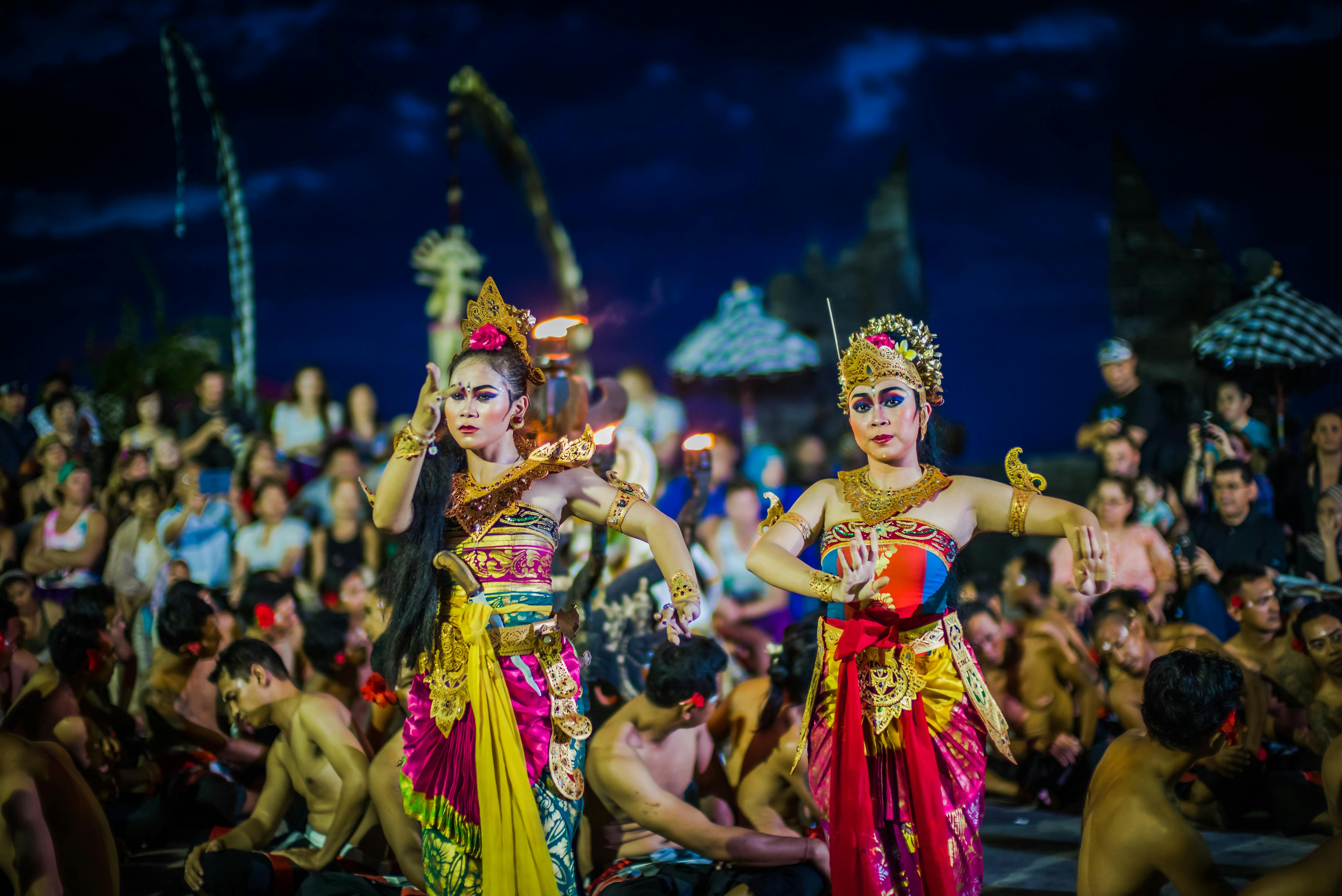 Balinese dancers performing in colorful traditional costumes during a temple ceremony