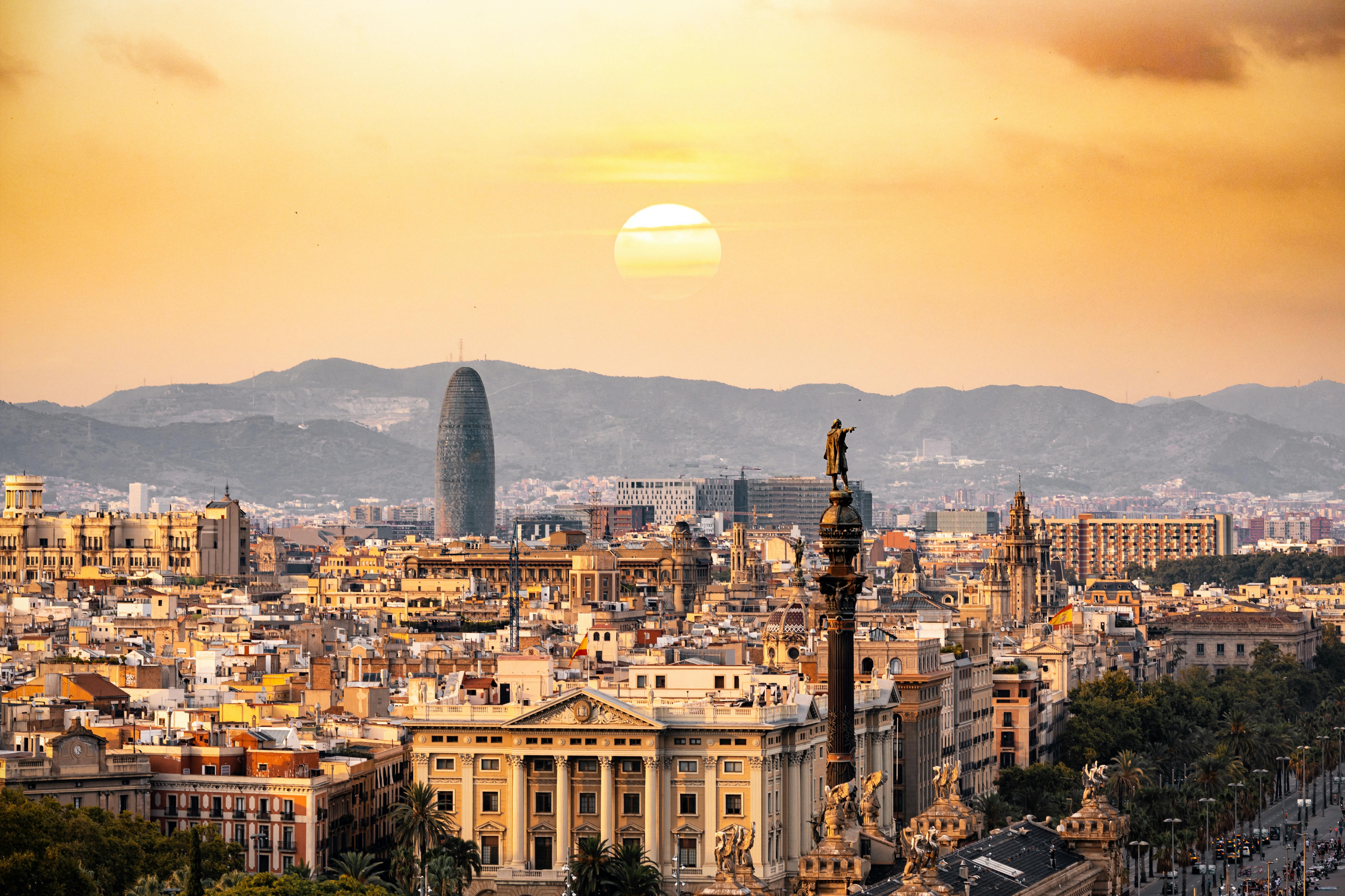Aerial view of Barcelona at sunset with the sea and Sagrada Família skyline