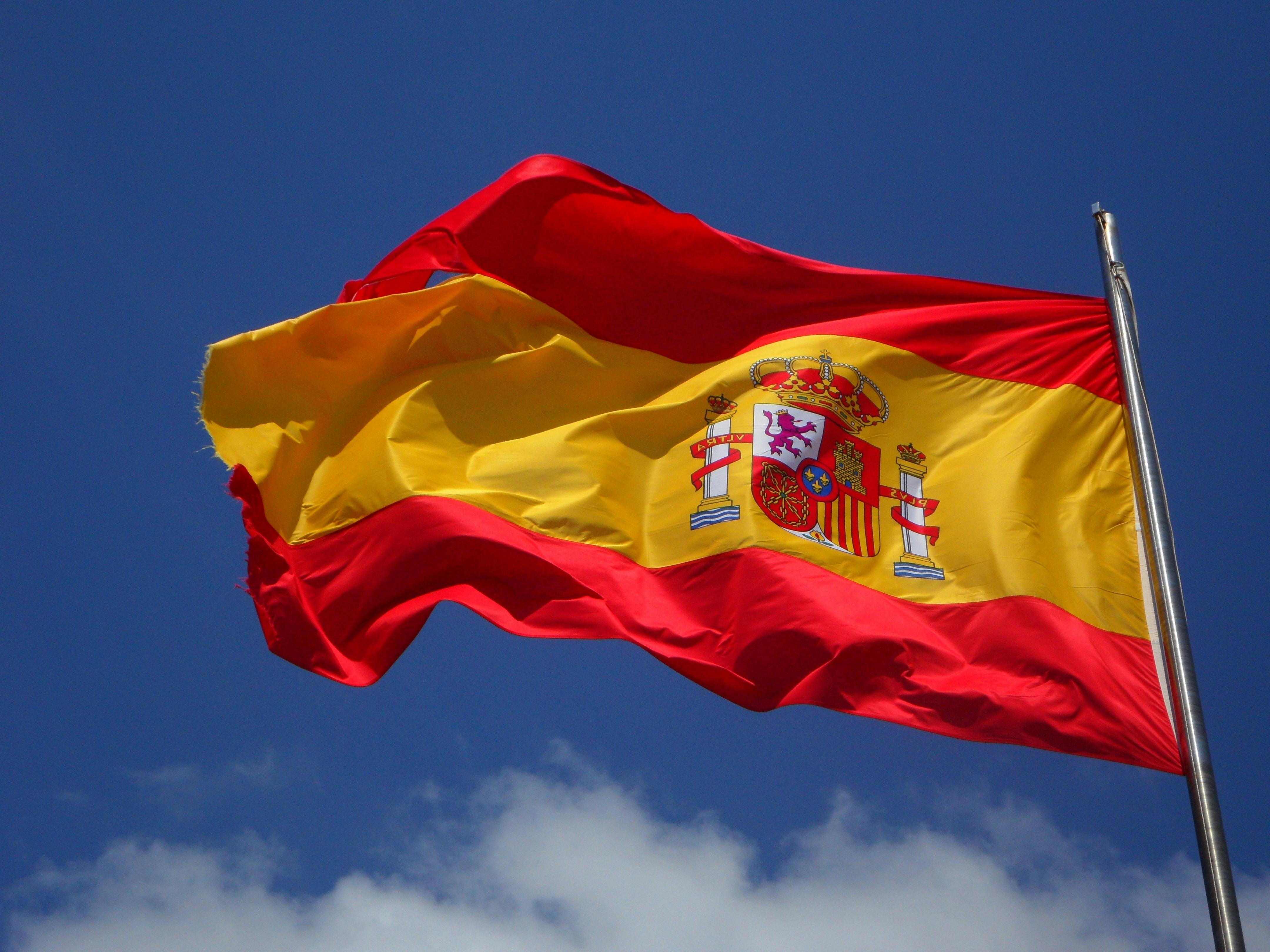 Spanish flag waving against a blue sky
