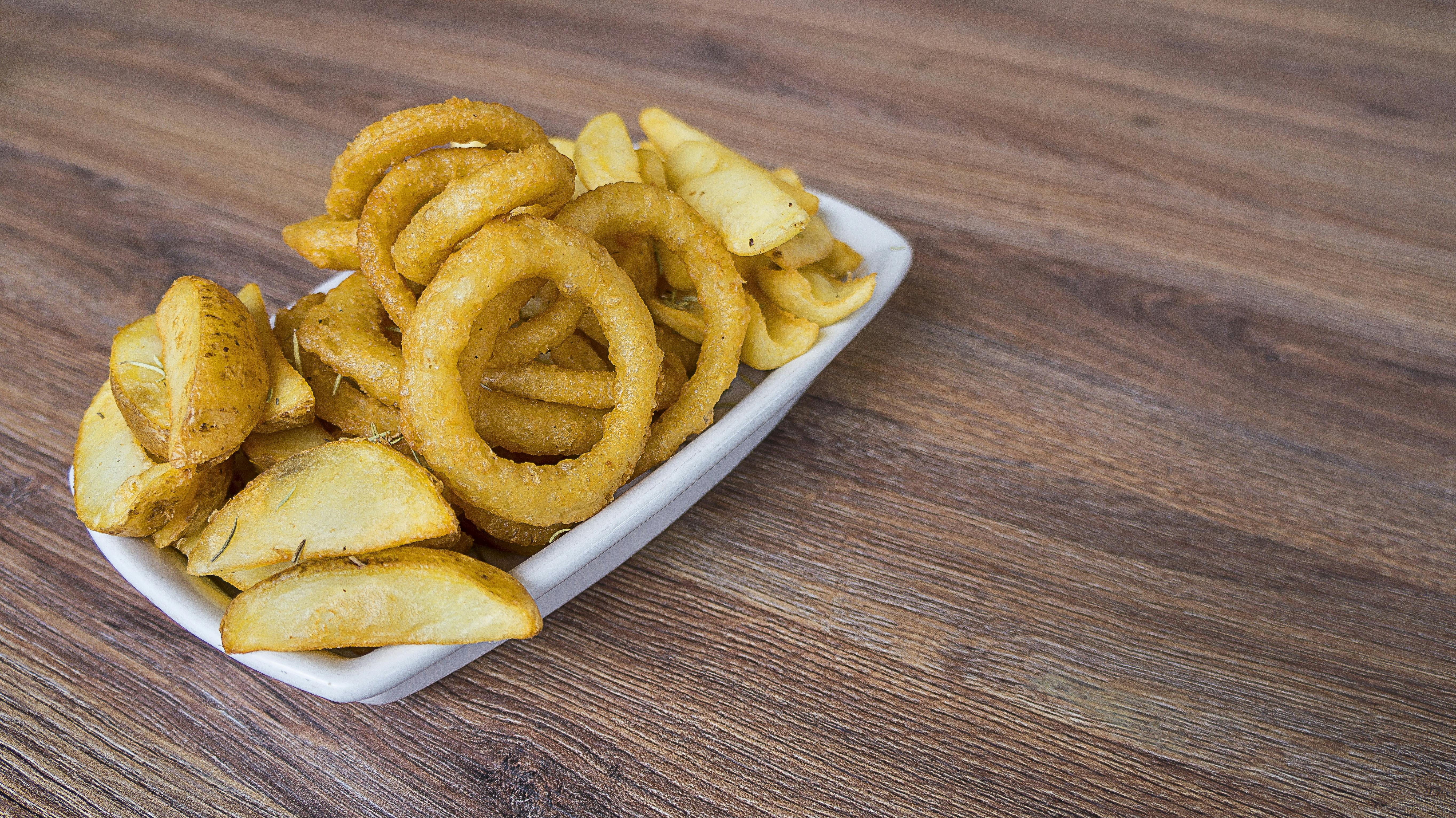 Plate of fried calamari rings and potatoes served in Galicia